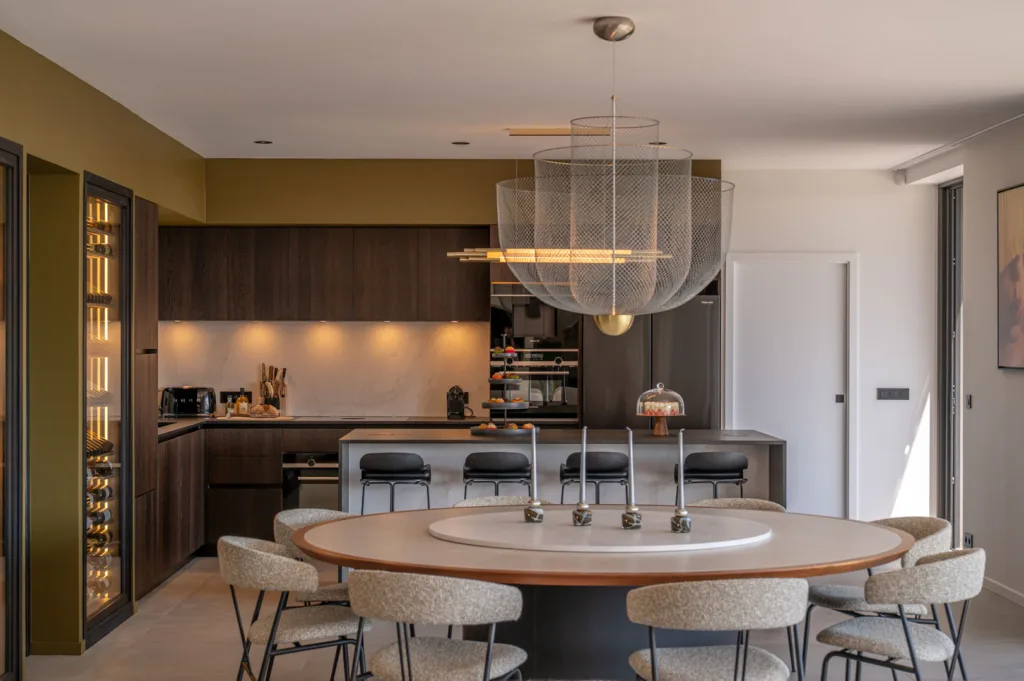 Salle à manger et cuisine de l'Hôtel Villa Padulaccia, grande table ronde sous une suspension en métal tressé