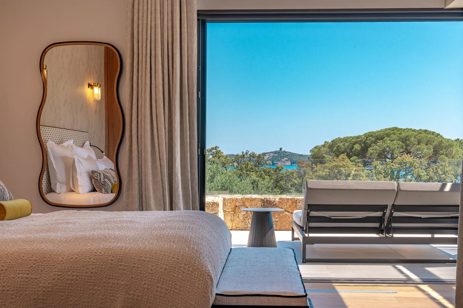 Chambre de l'Hôtel Villa Padulaccia ouverte sur une terrasse, vue sur la mer et la tour de l'île de Pinarellu